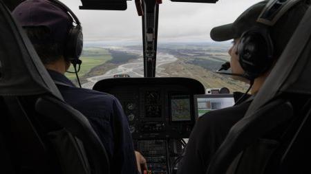 A woman and a man flying in a helicopter