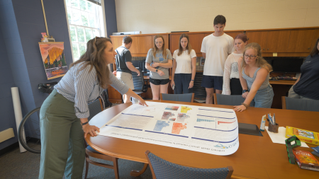 Professor shows poster with data to students