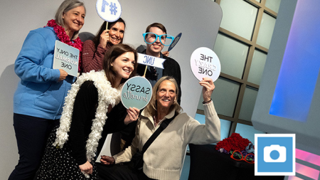 Carolina employees pose with signs at photo booth