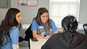 In between two students, Cassidy White works with two fellow students.